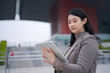 © zhouyilu - Business Professional Engaged with Tablet Outdoors in Modern Architecture