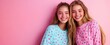 © Suphanny - Smiling Girls in Colorful Polka Dot Shirts, Two cheerful teenage girls wearing colorful polka dot shirts, posing against a pink background, radiating happiness and friendship.