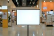 © HO - A blank smart TV screen on a vertical stand in a brightly lit tech store showroom, ready for a display demo.