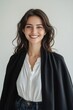 © Oulaphone - A smiling woman wearing a white blouse and a black shawl poses against a neutral background, exuding warmth and confidence.