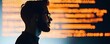 © PBMasterDesign - Businessman silhouettes concept. A thoughtful programmer analyzing code on a digital screen in a modern workspace.
