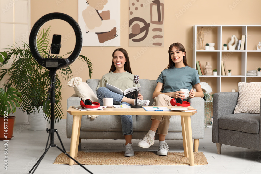 Young sisters with magazine recording podcast at home