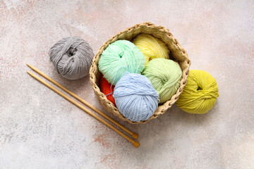 Wall Mural - Wicker basket with colorful knitting yarn and needles on light grunge background