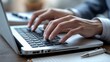 © Abi - Close-Up of Hands Typing on a Laptop in a Workspace Setting