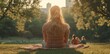 © sangkutcek - A serene scene of a woman sitting on grass, enjoying a sunset in a park.