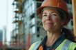 © NBLX - Portrait of smiling senior woman in hard hat helmet and safety vest at construction site