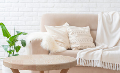 Wall Mural - wooden round coffee table with copy space in front of blurred living room interior with couch backgr