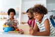 © NDABCREATIVITY - Happy smiling african american parents enjoy weekend play with child in kitchen. Family love concept