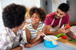 © NDABCREATIVITY - Overjoyed young african american family with kid have fun cooking at home together,