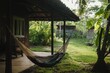 © Alla - A hammock hung between two tree branches in a backyard, ready for relaxation