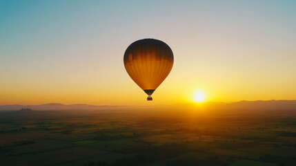 Wall Mural - hot air balloon floats over a picturesque landscape at sunrise with golden hues illuminating the sky