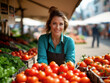 © jocaja - Vendedora sonriente en un mercado al aire libre, rodeada de tomates frescos y verduras frescas.