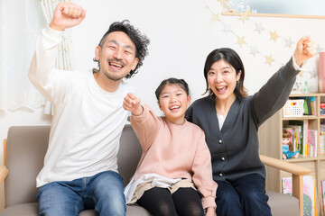 Sticker - 自宅で過ごす仲良し小学生の子供と夫婦の3人家族のイメージ　カメラ目線のガッツポーズで成功のイメージ