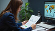 © Mikhael - Businesswoman analyzing charts and maps in a modern office.