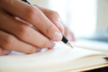 Selective Focus on Woman’s Hand Writing in a Journal