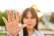 © Oscar - Close-up of a Latina woman with hand extended towards the camera, blurred background