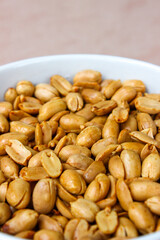 Wall Mural - Close up of Roasted salted peanut on a white bowl