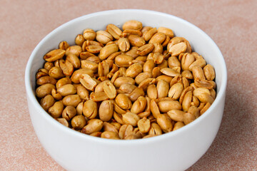 Wall Mural - Close up of Roasted salted peanut on a white bowl