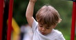 © Marco - Toddler boy climbing monkey bars at playground outside. Child climbs down
