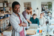 © Geber86 - Portrait of a young architect looking at the camera while in his office working on a project with his team