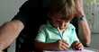© Marco - Little toddler boy doodling on paper while sitting on grand-father lap
