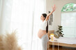 © tonefotografia - Happy smiling pregnant woman in her bedroom at home