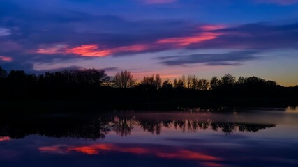 Fototapete - Stunning sunset over tranquil lake with vibrant pink and purple sky reflecting on calm waters