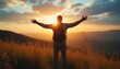 © natakot - A man stands on a mountain peak, arms wide open, basking in the golden glow of a breathtaking sunset. The scene captures a moment of pure joy and freedom, with rolling hills and vibrant skies creating