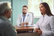 © Goran - Female nurse talking to her senior patient at doctor's office.