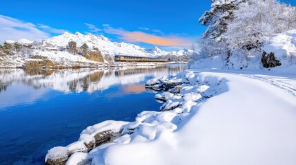 Canvas Print - Scenic winter landscape with train and snowy mountains reflected in calm blue water.