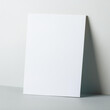 © hardvicore - Blank white poster on light gray background. Empty canvas template. Mock-up.