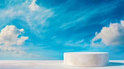 Wall Mural - a white pedestal on a concrete surface with a blue sky and clouds in the background