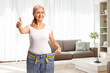 © Ljupco Smokovski - Middle aged woman gesturing thumbs up and trying on jeans at home