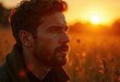 © Vibudhaart - Man with beard, gazing at sunset in a field, bathed in golden light.