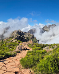 A stunning mountain trail at Pico do Arieiro, Madeira, Portugal. Rugged pathways, lush greenery, and clouds wrapping the peaks create a mesmerizing and adventurous hiking experience.