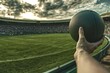 © Nana - A person holds a ball in a stadium, with a crowd and cloudy sky in the background.