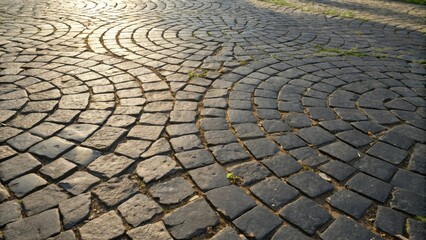 Fototapete - A circular pattern of weathered cobblestone paving stones, with light filtering through the gaps, illuminating the surface with a gentle glow.