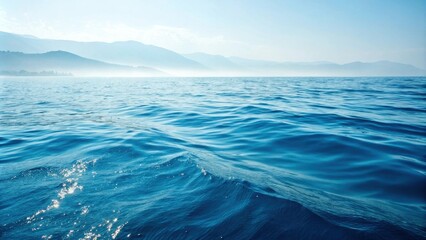 Poster - A serene ocean landscape with gentle waves and a distant mountain range, captured in a beautiful blue hue.