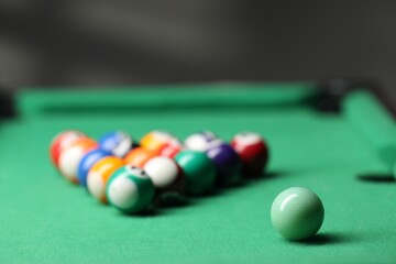 Wall Mural - Billiard balls in triangle on green table indoors, closeup. Space for text