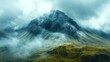 © Ali - Misty mountain peak, verdant slopes, dramatic clouds.