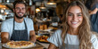 © bborriss - Pizzeria staff smiling and showing pizza in restaurant kitchen
