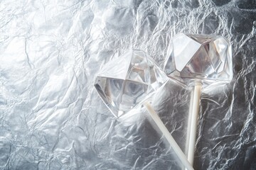 Poster - Two diamond shaped lollipops on shiny foil.