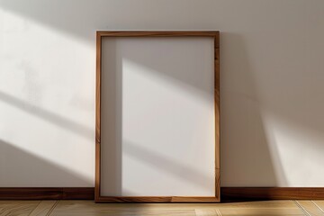 Wall Mural - Empty wooden frame rests against a plain wall while soft light casts shadows across the floor during the afternoon