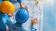 © Vilaysack - Two workers in safety helmets examine architectural blueprints, collaborating on a construction project.
