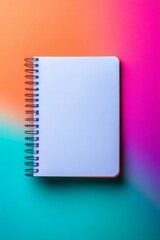 Wall Mural - a spiral bound notebook is open to a blank page. the notebook is on a colorful background, which add