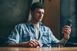 © BullRun - Confused hipster guy reading email with bad news from colleague using application for chatting on smartphone device, concentrated man puzzled on watching video in social networks via cellular