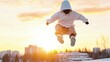 © kinara art design - Person in white hoodie jumping at sunset.