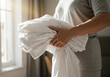 © Toast Img - Closeup of a Person Holding Clean Linen to Change Bed Sheets
