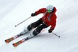 © kardaska - Skier wearing red jacket skiing downhill on snowy slope