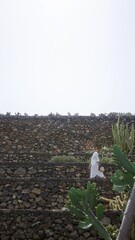 Sticker - Woman exploring the lanzarote cactus garden in canary islands, wearing a white dress, rocky steps, surrounded by unique greenery and bright sun, capturing the essence of outdoor beauty and nature